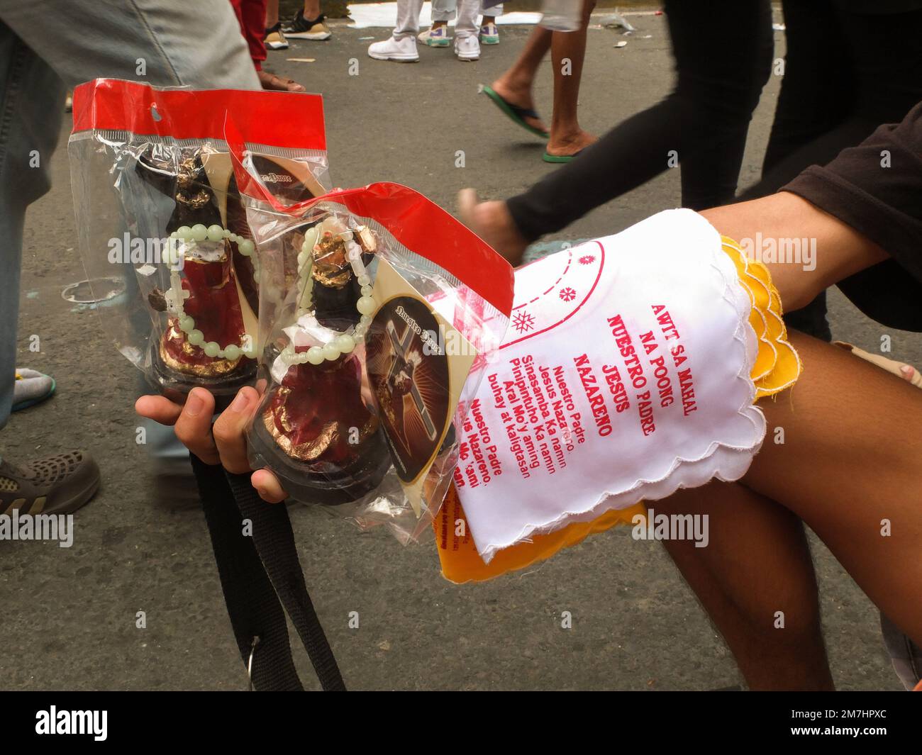 Manila, Philippinen. 09. Januar 2023. Ein Verkäufer in Quiapo, der seine Ware zeigt, schwarze Nazarener Miniaturreplikate und Taschentücher. Nach zwei Jahren der Beschränkungen der COVID-19-Pandemie können nun katholische Anhänger an der ersten großen Feier des Fests der Schwarzen Nazarener teilnehmen. Hunderttausende Anhänger tauchten in der Quiapo Kirche und anderen wichtigen Straßen in Manila auf, um ihre Hingabe für die Nachbildung des dunkelhäutigen Jesus Christus aus dem 17. Jahrhundert zu zeigen. Kredit: SOPA Images Limited/Alamy Live News Stockfoto