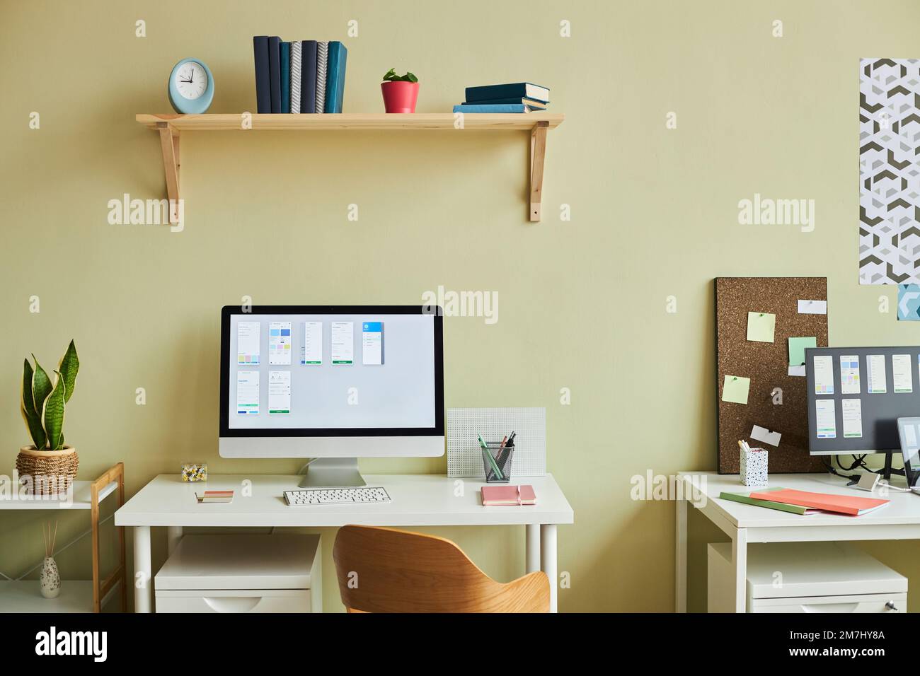 Hintergrundbild eines minimalen Büroaufbaus mit Computerbildschirm und Planungstabellen vor pastellgelber Wand, Kopierbereich Stockfoto