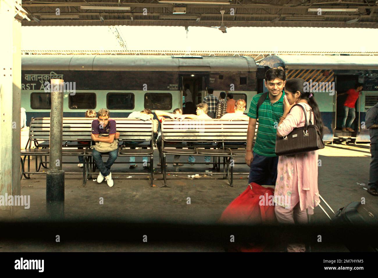 Passagierpaare, die sich unterhalten, während sie auf dem Passagiersteig am Bahnhof von Neu-Delhi in Neu-Delhi, Delhi, Indien, stehen. Stockfoto