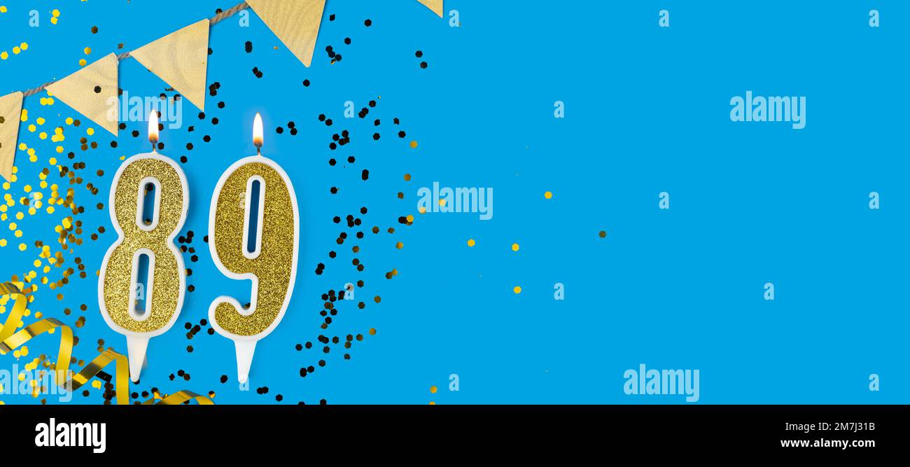 Goldene Kerze Nummer 89. Geburtstagskarte mit der Aufschrift 89 auf blauem Hintergrund. Jubiläumsfeier. Banner. Stockfoto