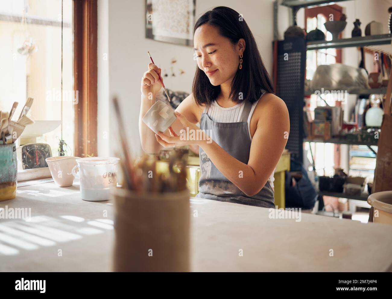 Töpferei, Kunst und Kreativität mit einer asiatischen Frau in einem Studio für Design- oder Keramik-Hobby als Kunsthandwerkerin. Fertigung, Muster und Künstler mit einer Frau Stockfoto