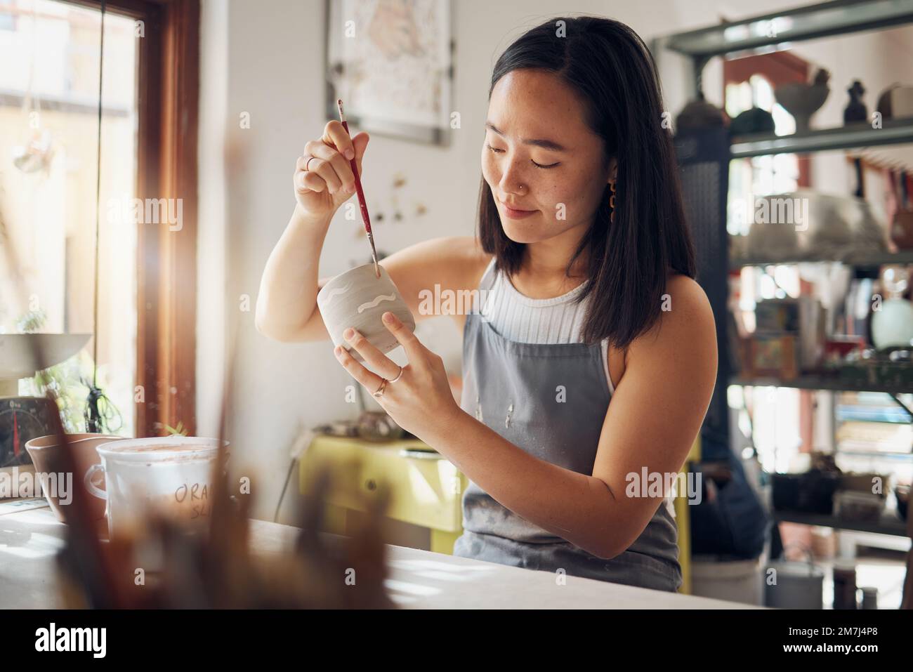 Töpferei, Kunst und Design mit einer asiatischen Frau in einem Studio für ihr kreatives Keramik-Hobby als Kunsthandwerkerin. Fertigung, Muster und Künstler mit einer Frau Stockfoto