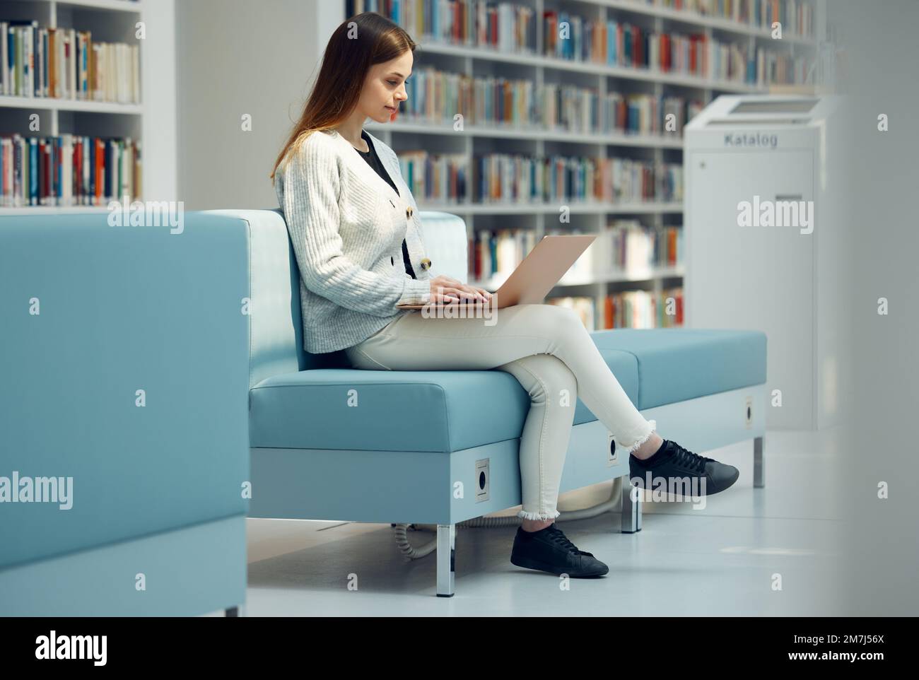 Bibliothek, Recherche und Mädchen mit Laptop auf dem Sofa für Bildung, Lernen und Online-Bericht schreiben. Ideen, Wissen und Mädchen in der modernen Buchhandlung Stockfoto