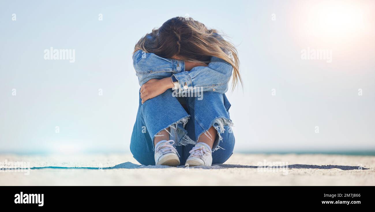 Traurige Frau, Stress oder Depression am Strand, Meeresumwelt oder Naturmeer mit bipolar, Einsamkeit oder Burnout. Psychische Gesundheit, Angst oder Verwirrung Stockfoto