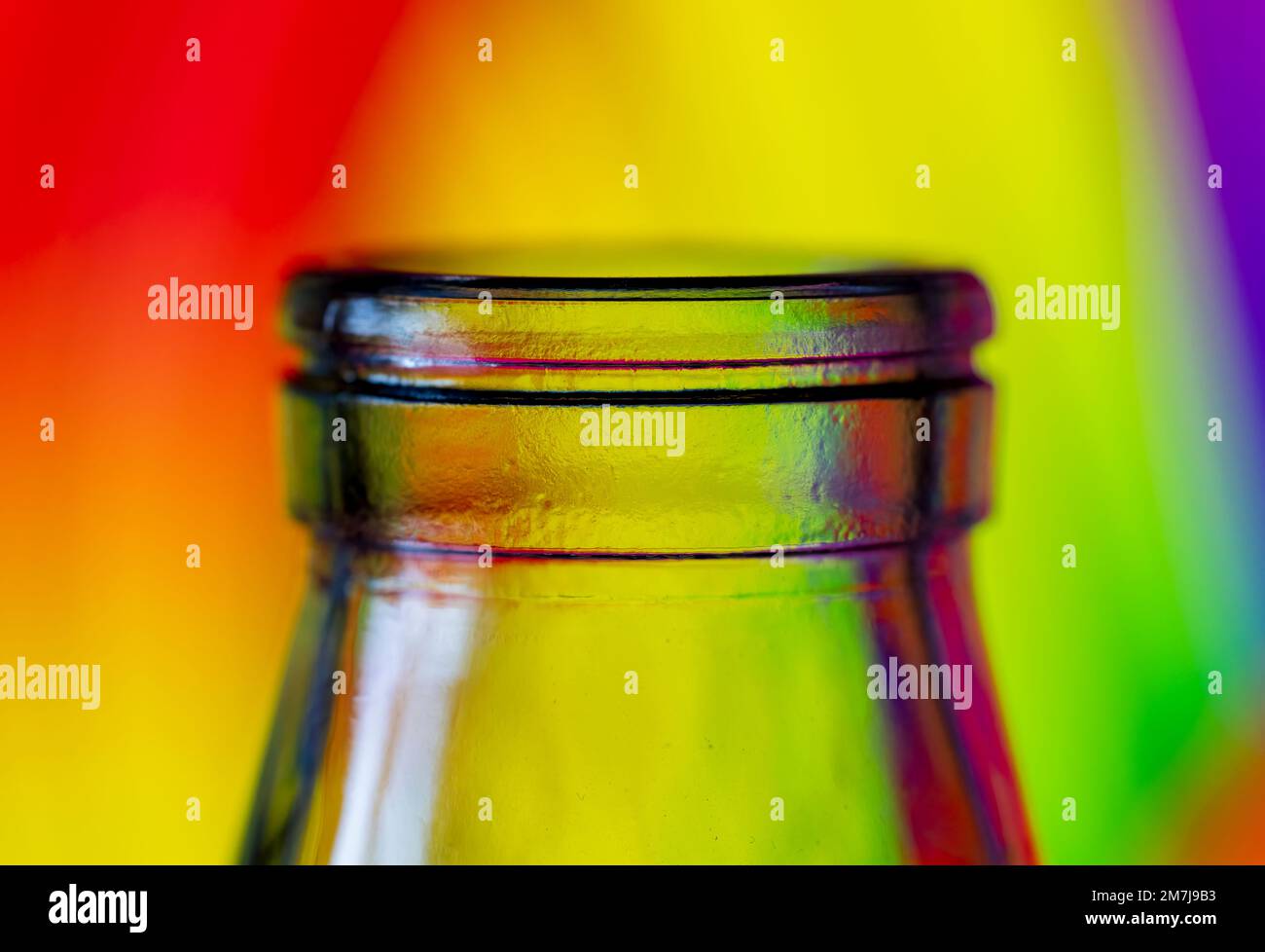Nahaufnahme der Oberseite einer Glasflasche, fotografiert vor einem mehrfarbigen Hintergrund Stockfoto