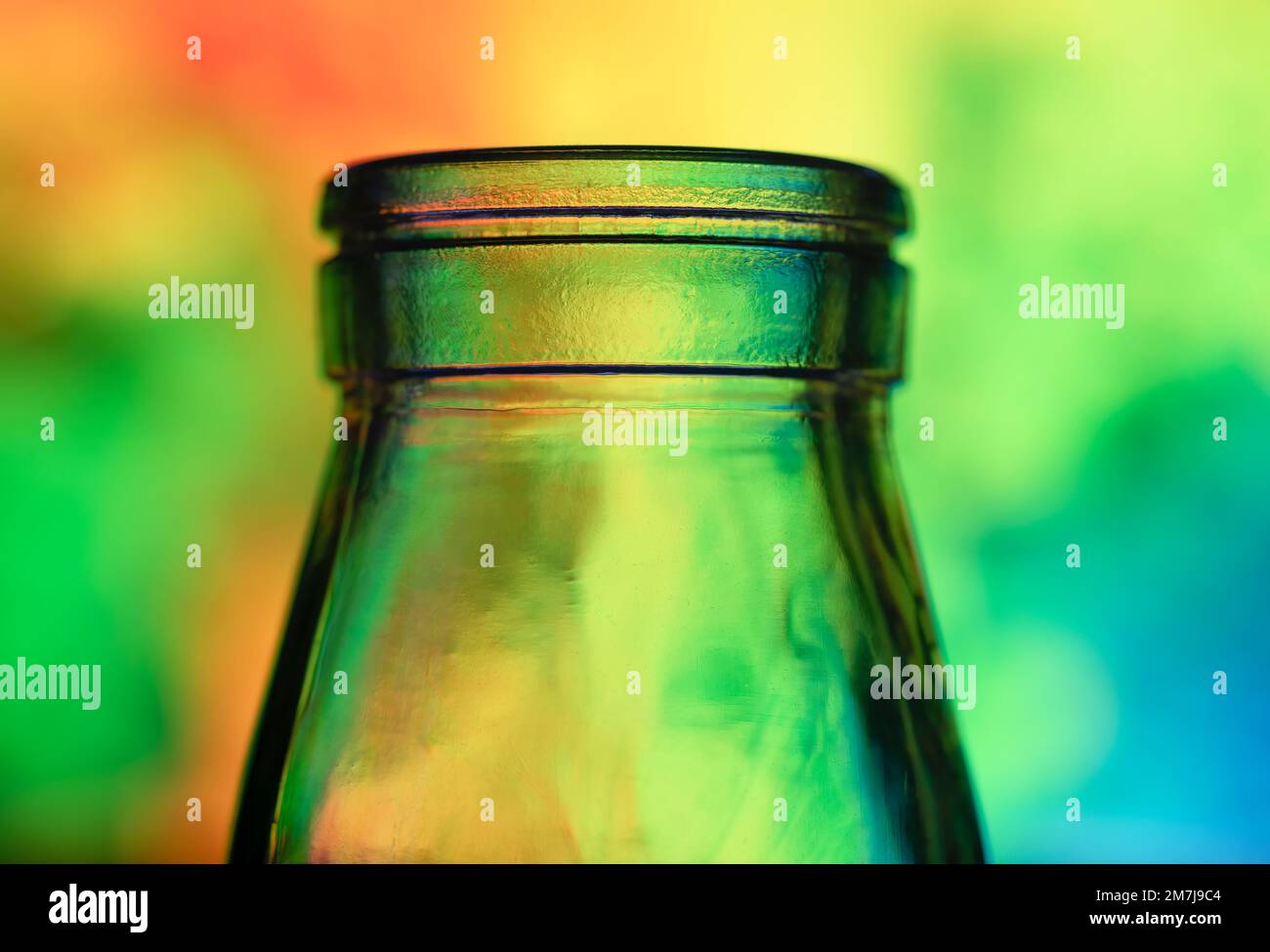 Nahaufnahme der Oberseite einer Glasflasche, fotografiert vor einem mehrfarbigen Hintergrund Stockfoto