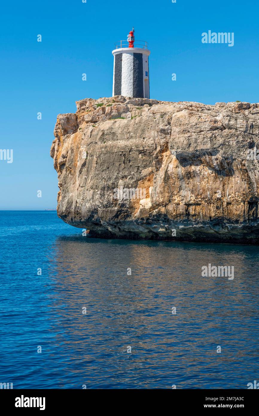 Der Leuchtturm auf dem Felsen Morro de Sa Carabassa am Eingang zur Bucht von Porto Cristo an der Ostküste von Mallorca. Stockfoto