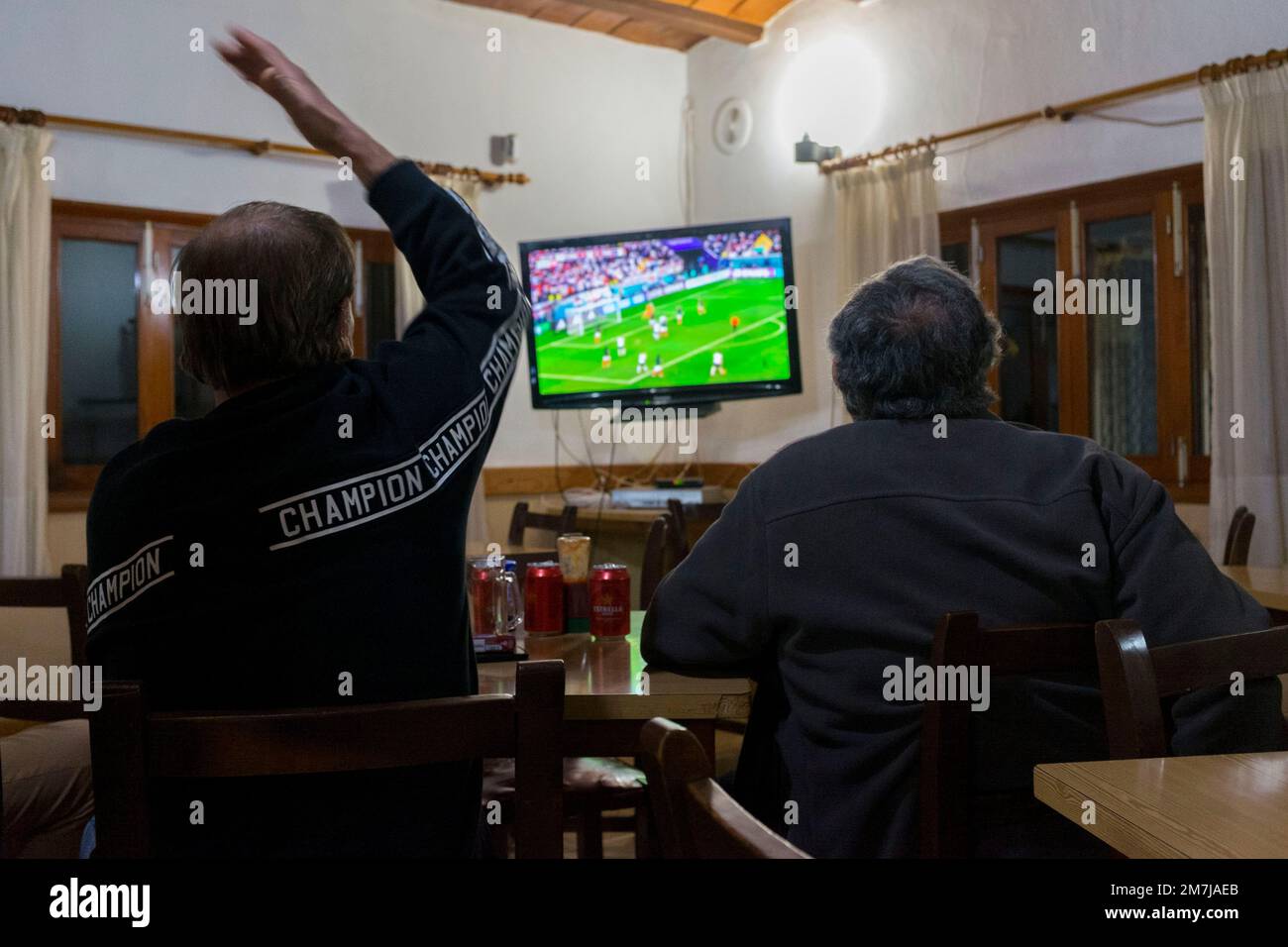 In einem spanischen Pub sehen zwei Besucher ein Fußballspiel im Fernsehen. Stockfoto