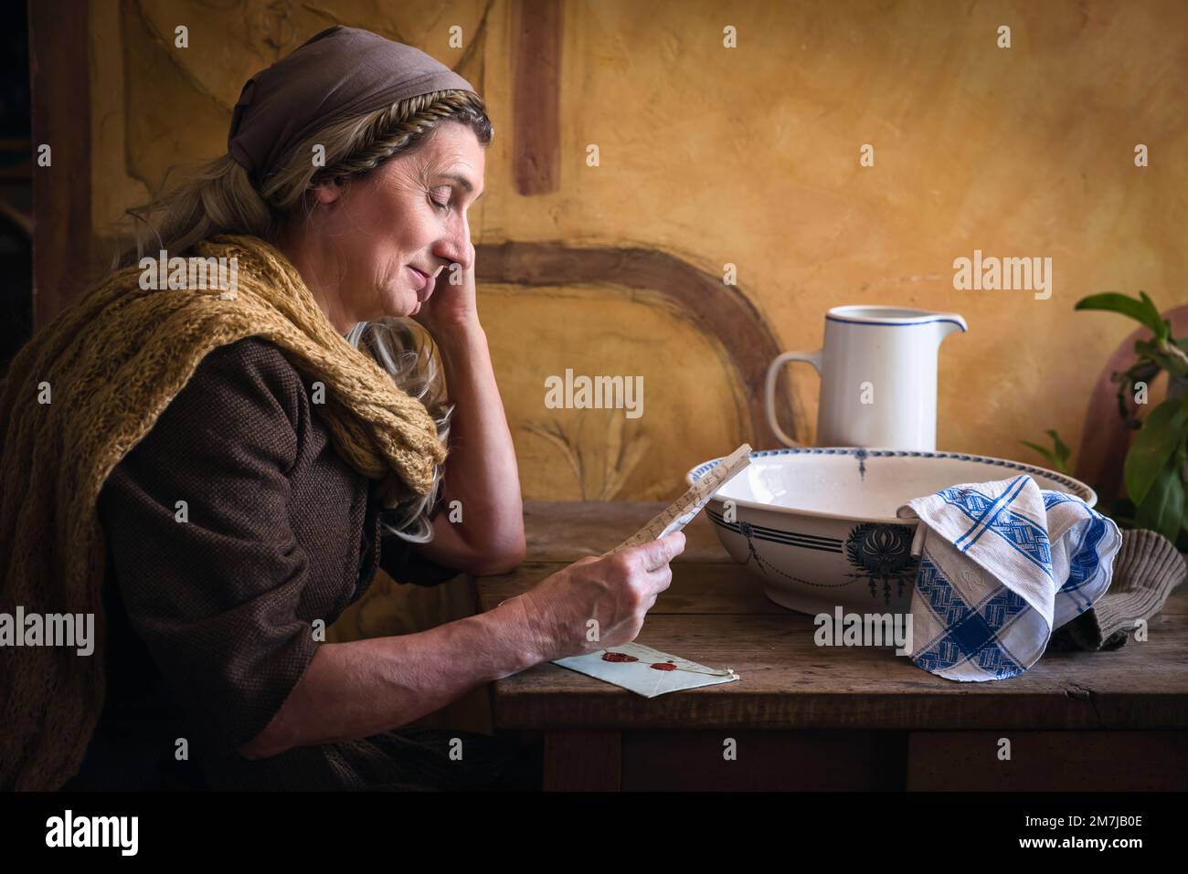 Eine Frau in authentischem Bauernrenaissance-Kostüm, die einen Brief liest Stockfoto