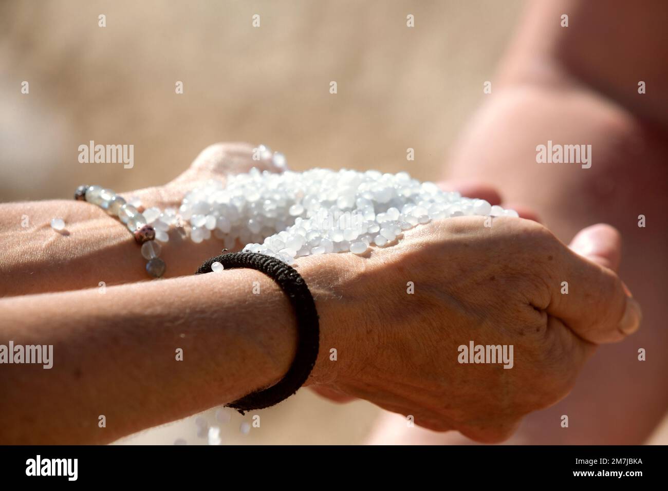 Tote Meersalzkristalle in Frauenhänden, natürliche Mineralien für die Gesundheit Stockfoto