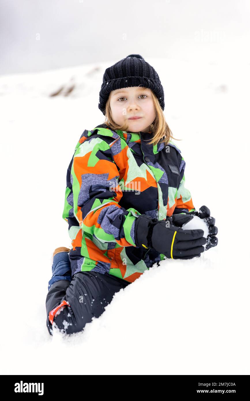Kleines Weißes Mädchen spielt im Schnee. Schau in die Kamera Stockfoto