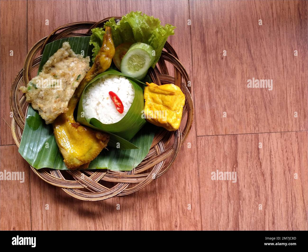 Köstliche indonesische Mahlzeit Nasi liwet von sudanesischem West-Java. Komplettes Set mit gebratenem Tofu, Mendoan-Tempeh, gebratenem Hähnchen und frischem Gemüse. Stockfoto