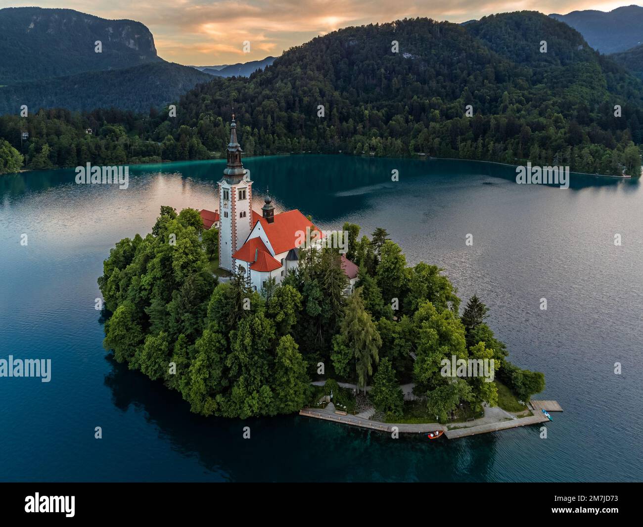 Bleder See, Slowenien - Luftaufnahme der Pilgerkirche zur Marienhimmelfahrt am Bleder See (Blejsko Jezero) mit Julianeralpen im Hintergrund Stockfoto