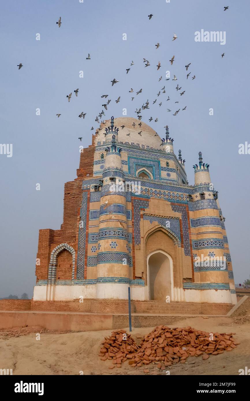 Landschaftsblick auf mittelalterliche Architektur des antiken achteckigen blauen Grabs von Bibi Jawindi mit fliegenden Tauben, uch Sharif, Bahawalpur, Punjab, Pakistan Stockfoto