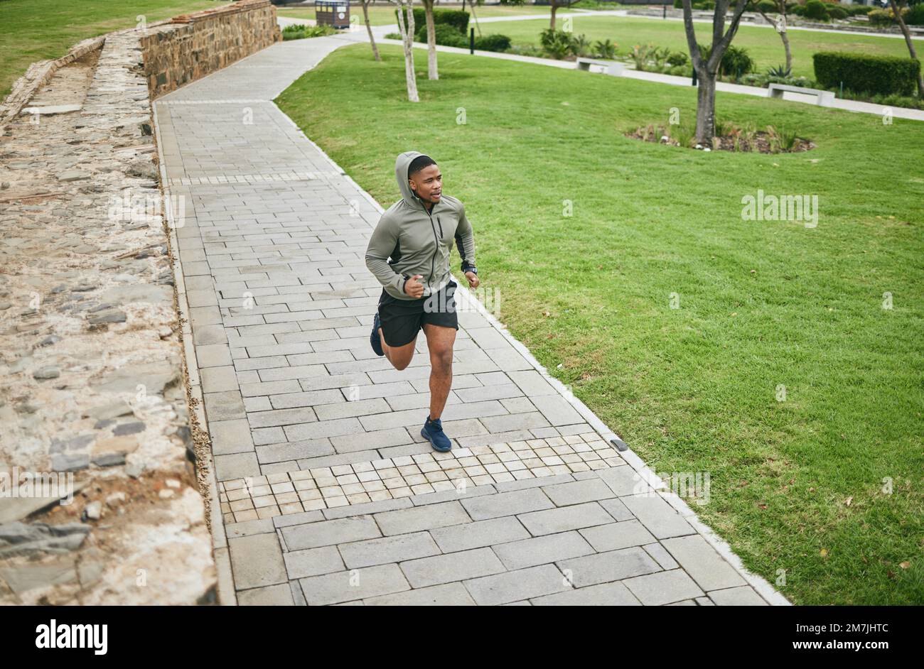 Fitness, Laufen und Black man Runner im Park für körperliches Training und Training, Cardio und Energie. Marathontraining, Laufen und Sportmotivation Stockfoto