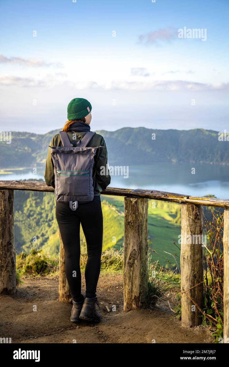 Junge Frau, die die malerische Aussicht auf die Insel São Miguel auf den Azoren bewundert Stockfoto