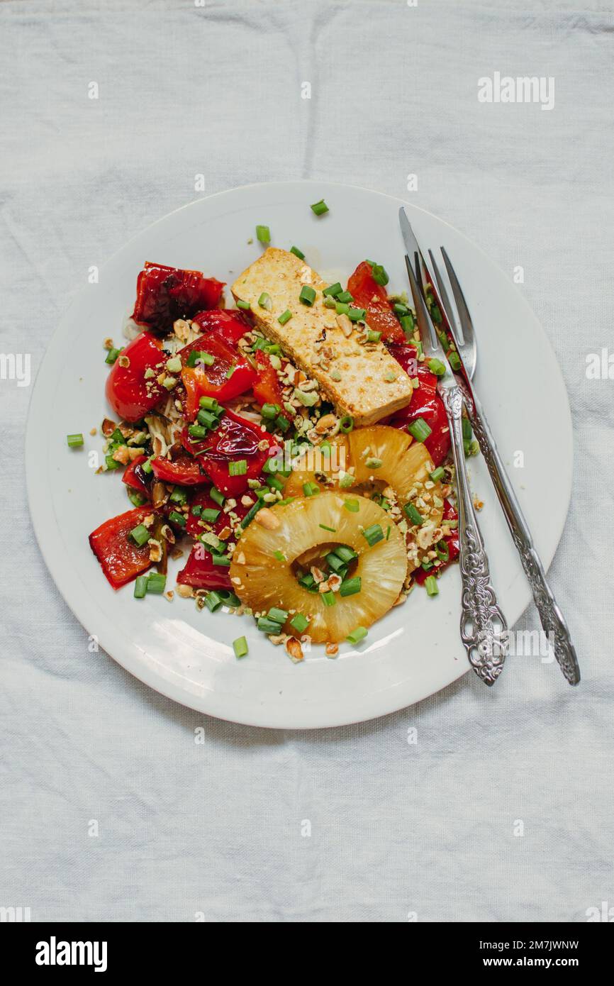 Gesundes vegetarisches Mittagessen mit Tofu-Käse, Gemüse und Nüssen auf hellem Hintergrund. Draufsicht. Geben Sie Platz für Ihren Text. Stockfoto