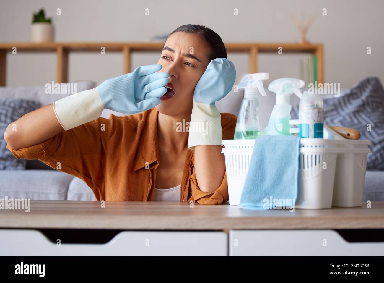 Putzen, gähnen und müde mit einer Haushälterin, die gähnt, während sie als Putzfrau in einem Heim arbeitet. Sauber, gelangweilt und hygienisch mit weiblichem Leiden Stockfoto