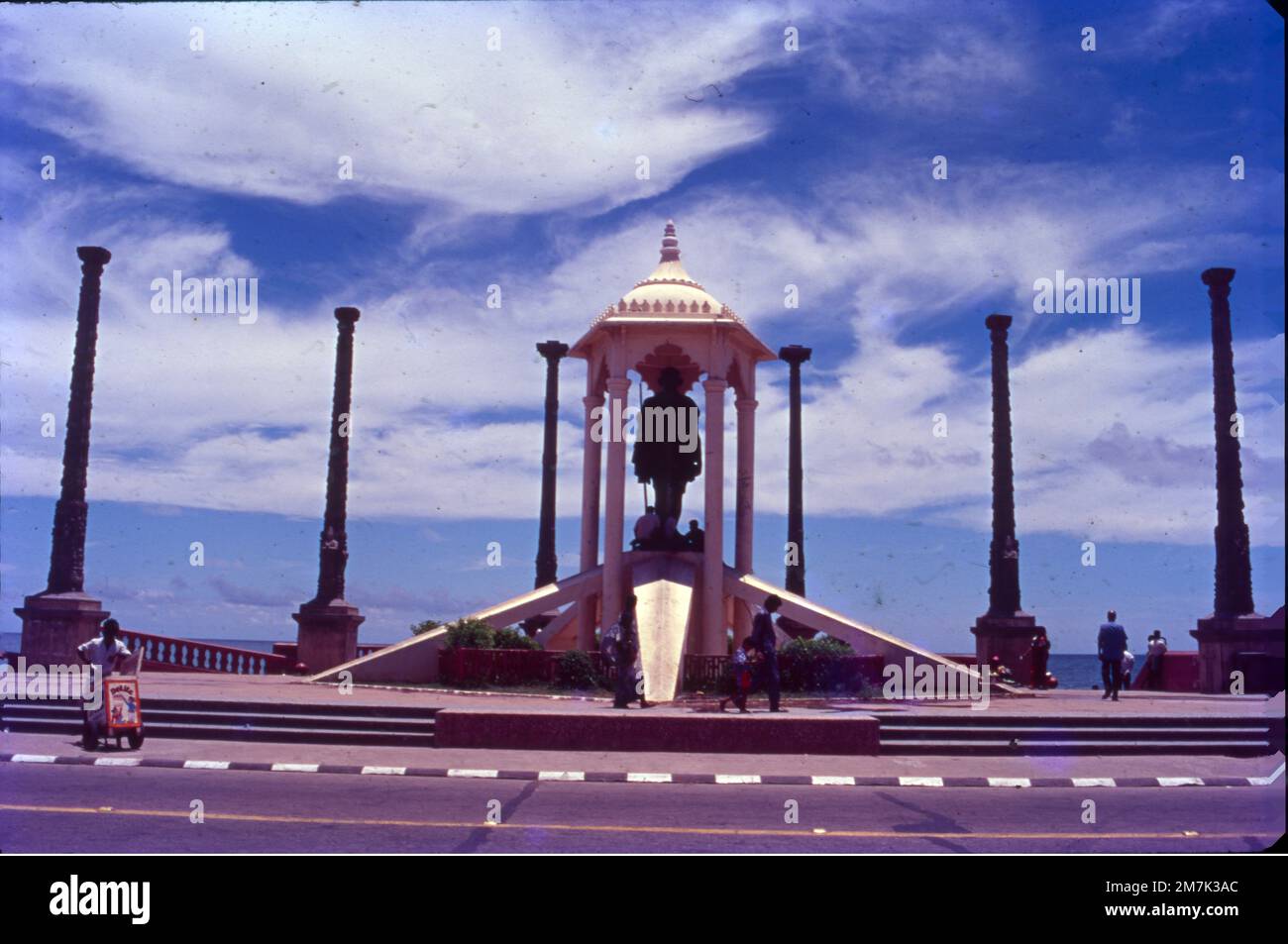 Ein weißes Gebäude, umgeben von Granitsäulen, beherbergt eine Bronzestatue des Unabhängigkeitsführers. Die Statue von Mahatma Gandhi in Pondicherry ist eine Hommage an den Vater der Nation, der im Jahr 1965 am Promenade Beach errichtet wurde. Es ist von acht exquisit geschnitzten monolithischen Granitsäulen umgeben, die aus dem Fort Gingee stammen. Die Statue ist 4 m (13 Fuß) hoch Stockfoto