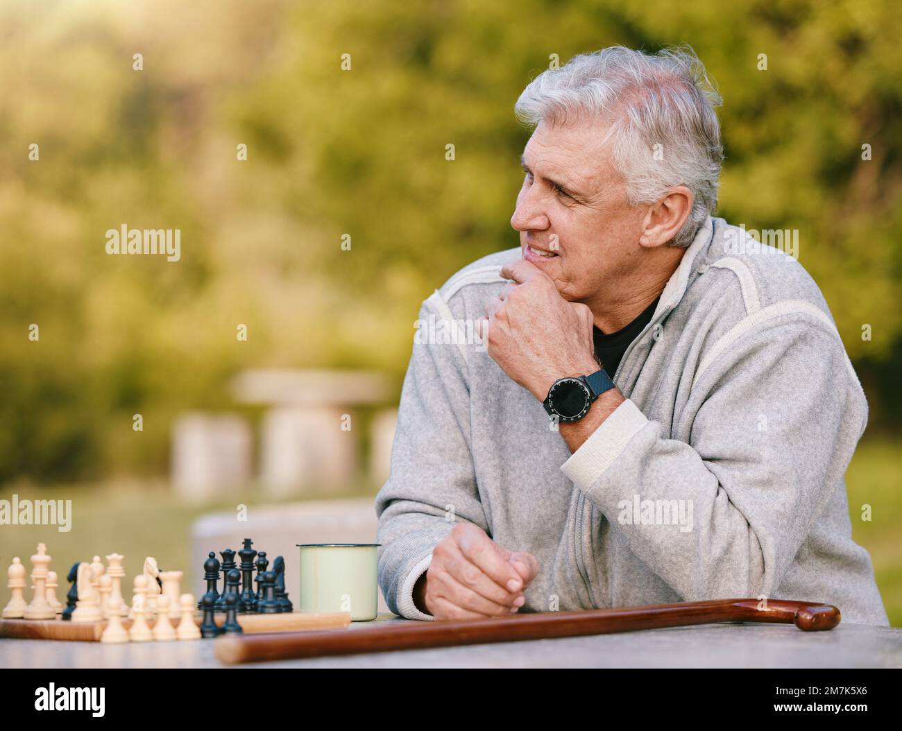 Seniorin, Park und Denken für Schach, Spiel und Wettkampf am Tisch bei Bäumen, Sonnenschein und Konzentration. Brettspiel für ältere Menschen, Outdoor und Strategie für Stockfoto