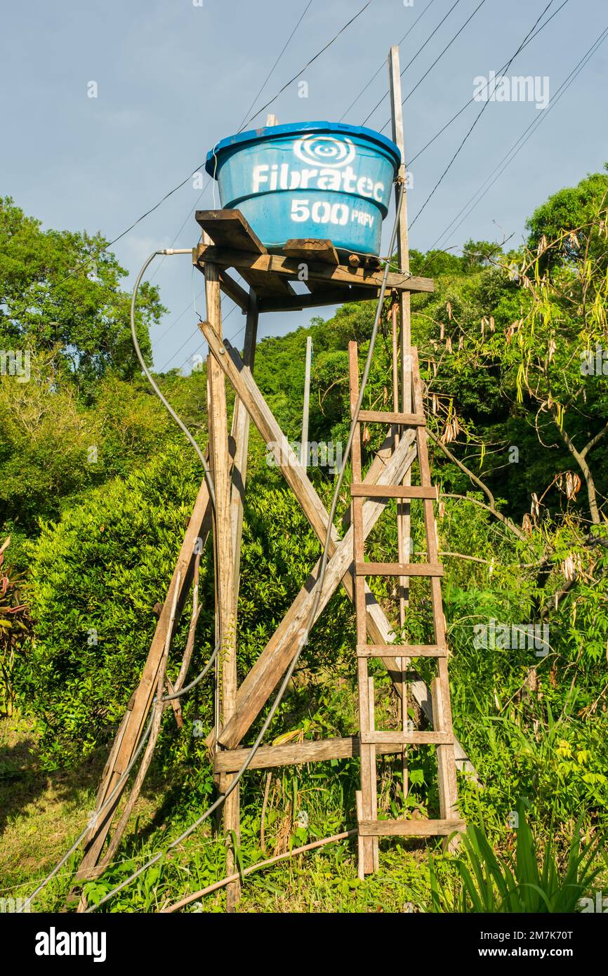 Sao Francisco de Paula, Brasilien - circa Dezember 2022: Wassertank auf einem hohen Holzgebäude in einem ländlichen Gebiet (Carapina Valley) Stockfoto