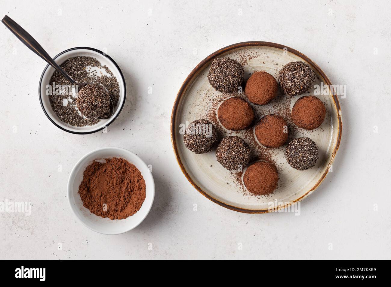 Datteln, Chiasamen und Kakaobälle auf Keramikplatte Stockfoto