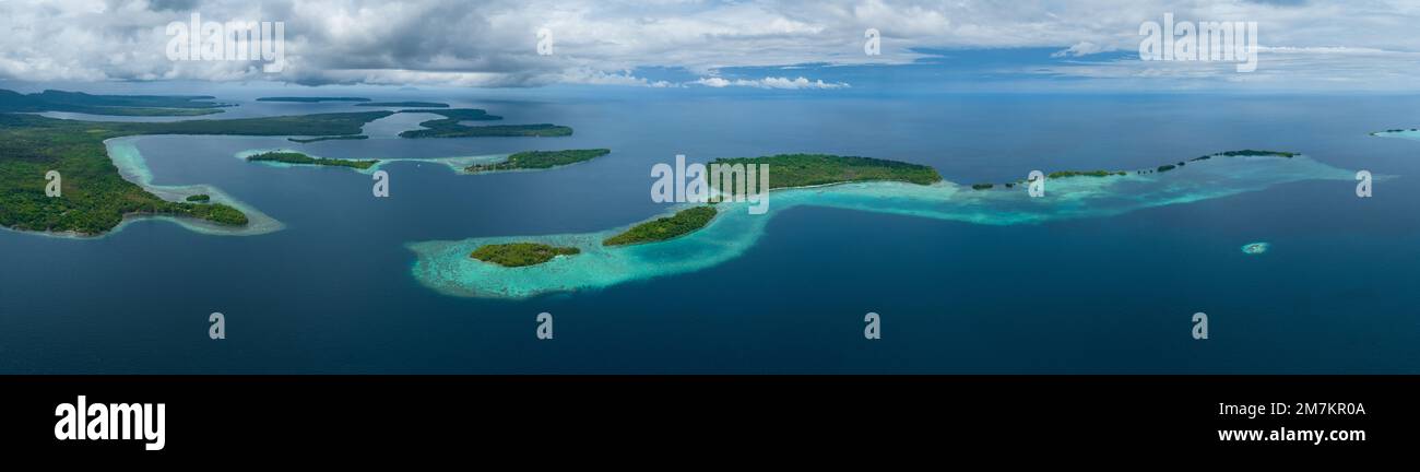 Ausgedehnte Korallenriffe säumen Regenwaldinseln auf den Salomonen. Dieses wunderschöne Land ist die Heimat einer spektakulären marinen Artenvielfalt. Stockfoto