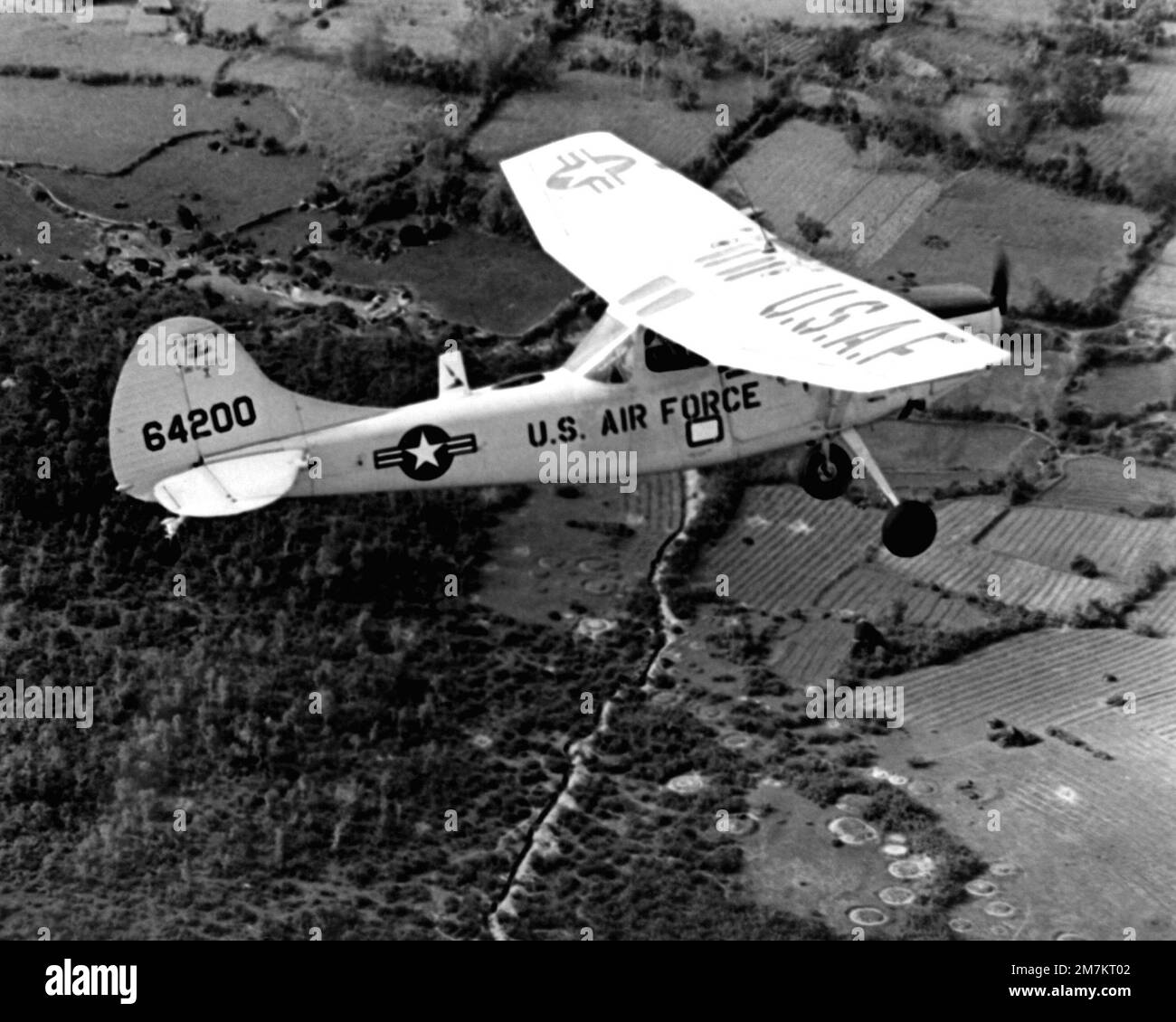 Eine Luft-Luft-Seitenansicht von rechts eines US-amerikanischen Air Force 0-1E Bird Dog Flugzeug. Das Flugzeug wird in ganz Südvietnam als Vorwärts-Luftkontrollflugzeug eingesetzt. Der vordere Luftkontroller (FAC) erkennt verdächtige feindliche Festungen und feuert Raketen ab, um das Ziel des angegriffenen Flugzeugs zu markieren. Nach einem Angriff beurteilt das FAC den Bombenschaden. Basis: Saigon Land: Vietnam (VNM) Stockfoto