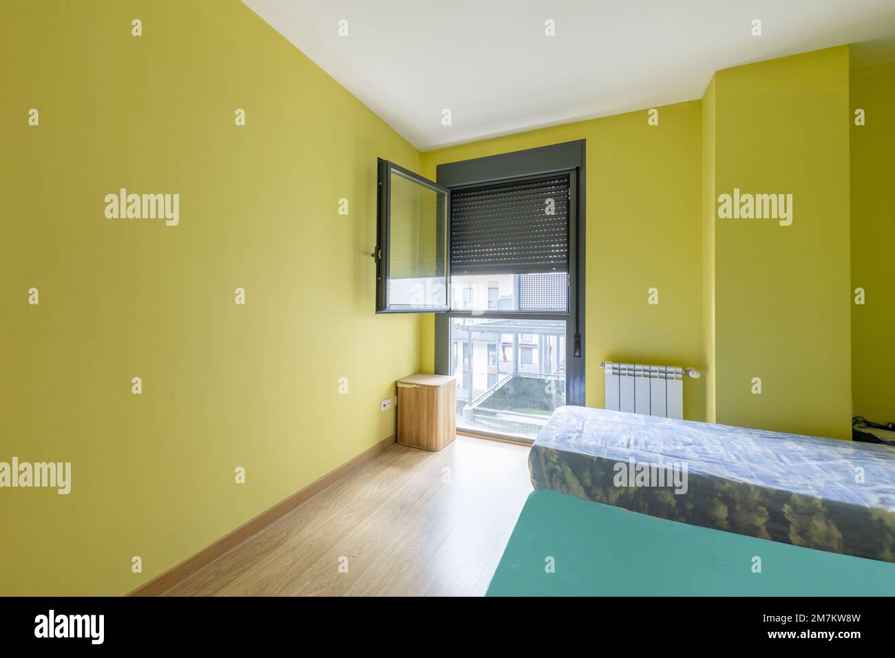 Schlafzimmer mit Einzelbetten, Balkon mit Jalousien und Wand in Pistaziengrün gestrichen Stockfoto