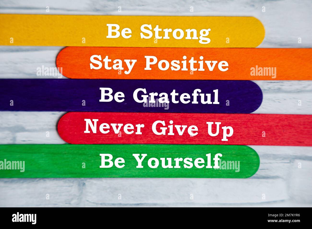 Motivierender Text auf bunten Stäbchen – sei stark, bleib positiv, sei dankbar, gib niemals auf und sei du selbst. Stockfoto