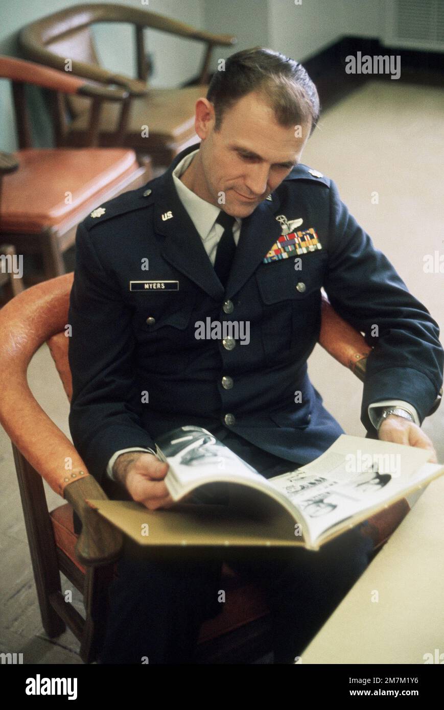 Ehemaliger Kriegsgefangener und USA Air Force LCOL Armand Jesse Myers durchsucht ein Buch über Vietnam-Kriegsgefangene in der Lounge des Krankenhauses. LCOL Myers wurde am 1. Juni 66 gefangen genommen und am 12. Februar 73 von den Nordvietnamesen in Hanoi freigelassen. Betreff Operation/Serie: HOMECOMING Base: Clark Air Base Staat: Luzon Country: Philippinen (PHL) Stockfoto