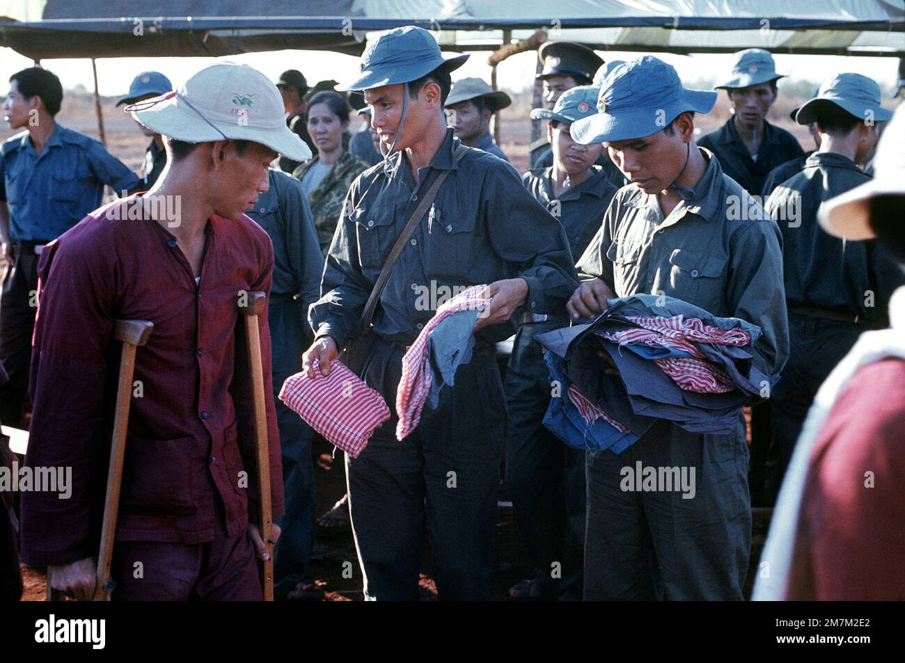 Mitglieder des Vietcong-Militärs verteilen neue Kleidung an die Vietcong-Kriegsgefangenen, die während des Gefangenenaustauschs zwischen Vietcong und Amerikanern und Südvietnamesen freigelassen wurden. Subjekt Operation/Serie: HOMECOMING-Basis: Loc Ninh Country: South Vietnam Stockfoto