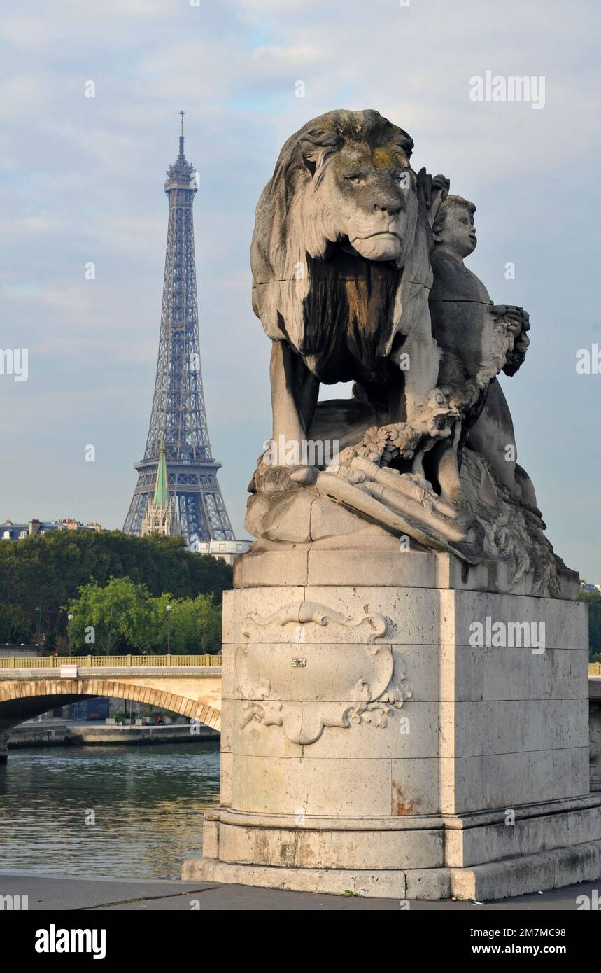 Der Eiffelturm steht hinter einer Löwenskulptur von Jules Dalou an der Brücke Pont Alexandre III über die seine in Paris. Stockfoto