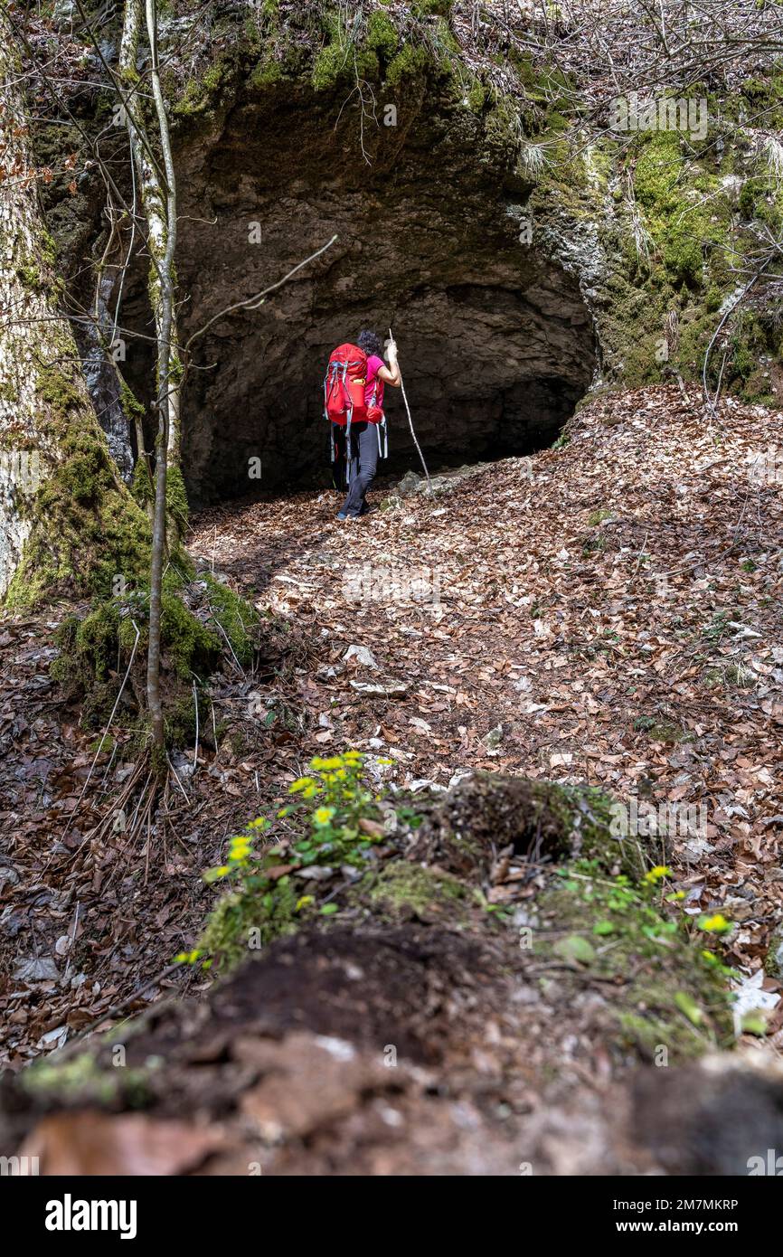 Europa, Deutschland, Süddeutschland, Baden-Württemberg, Donautal, Sigmaringen, Beuron, eine Frau schaut in eine Höhle im Bergwald Stockfoto