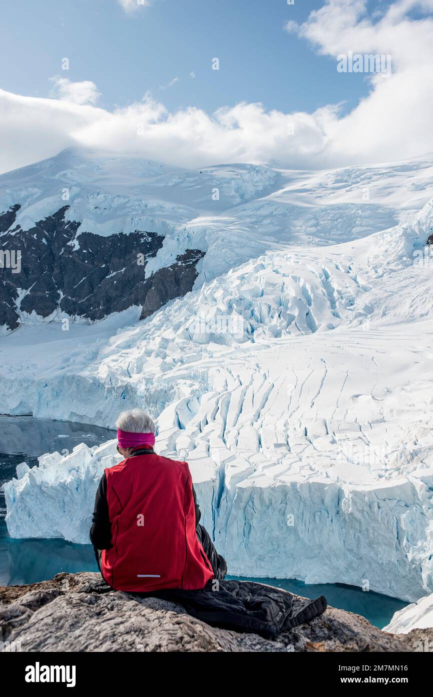Ein Tourist im Hafen von Neko, antarktis, beobachtet, wie der Gletscher knackt, bevor er ins Meer fällt Stockfoto