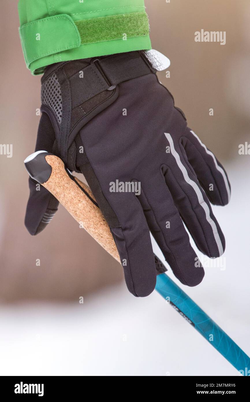 Nordic Walking. Gesunder Lebensstil, Outdoor-Sport im Winter. Die Hand eines Mannes drückt beim Nordic Walking den Griff eines Gehstock. Befestigen Sie einen Stick an Ihrem Stockfoto