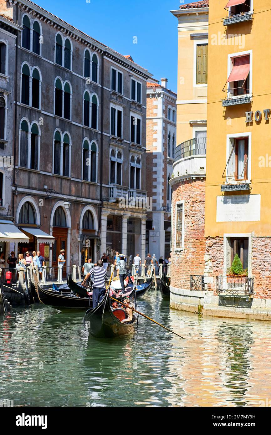 Gondoliere fahren Touristen durch die Lagunenstadt in Venedig Stockfoto