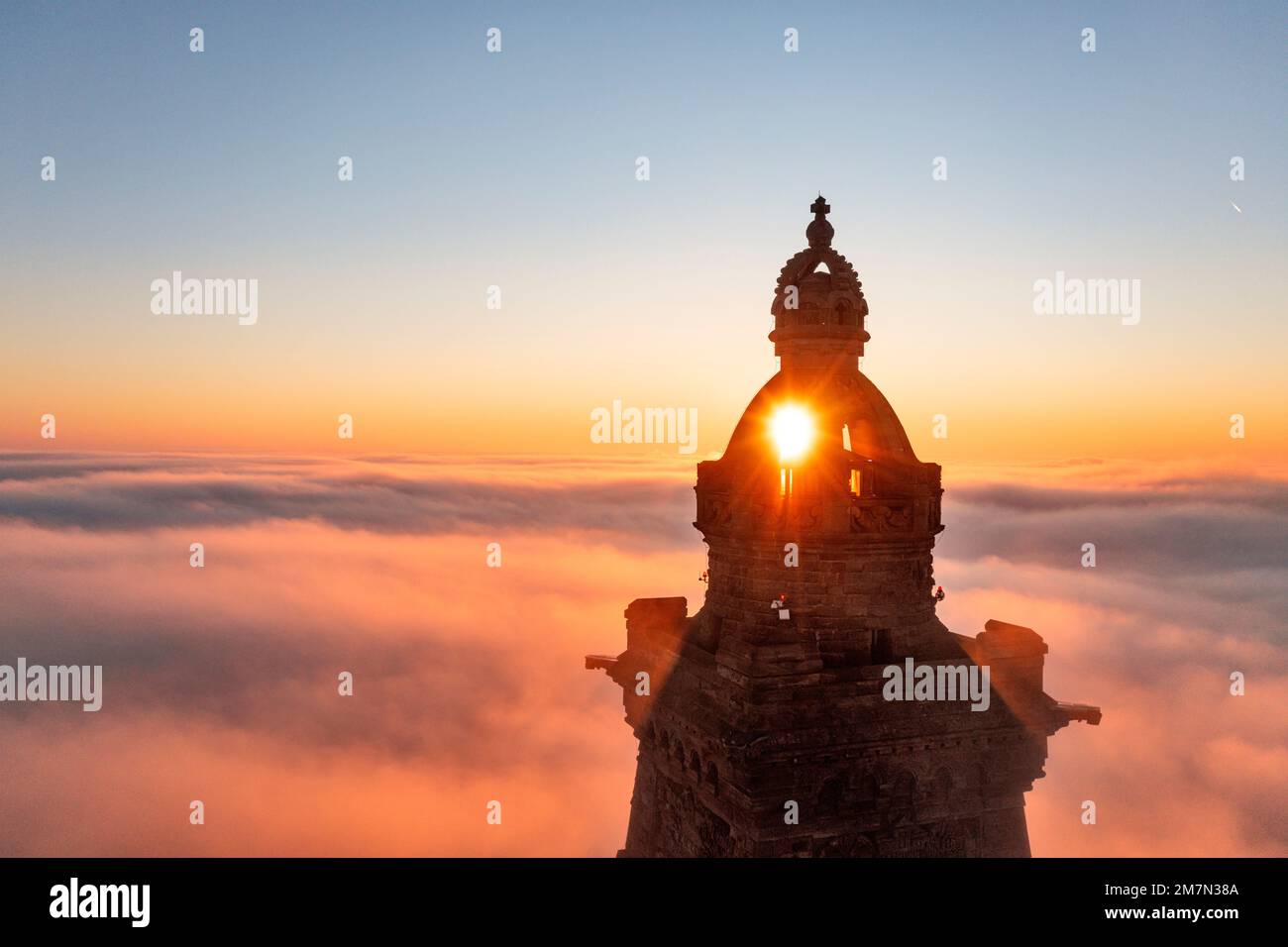 Deutschland, Thüringen, Bad Frankenhausen, Turm des Kyffhäuser Monuments erhebt sich aus niedrigen Wolken, Sonne geht auf und scheint durch Turmkuppel, Hintergrundlicht Stockfoto