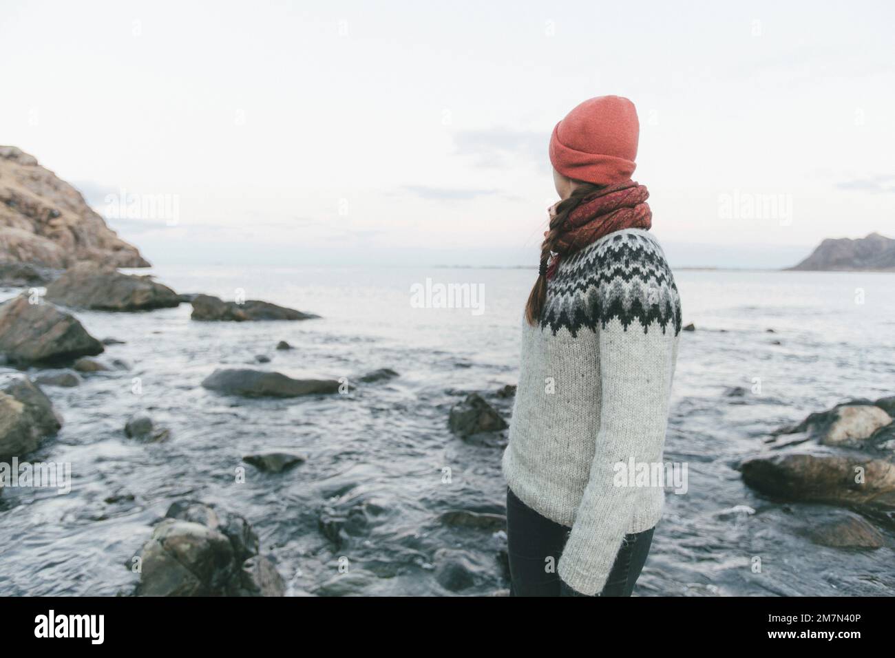 Junge Frau mit roter Mütze am Strand Stockfoto