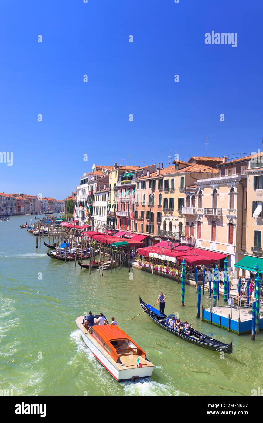 Ein Motorboot und eine Gondelfahrt nebeneinander auf dem Canale Grande in Venedig Stockfoto