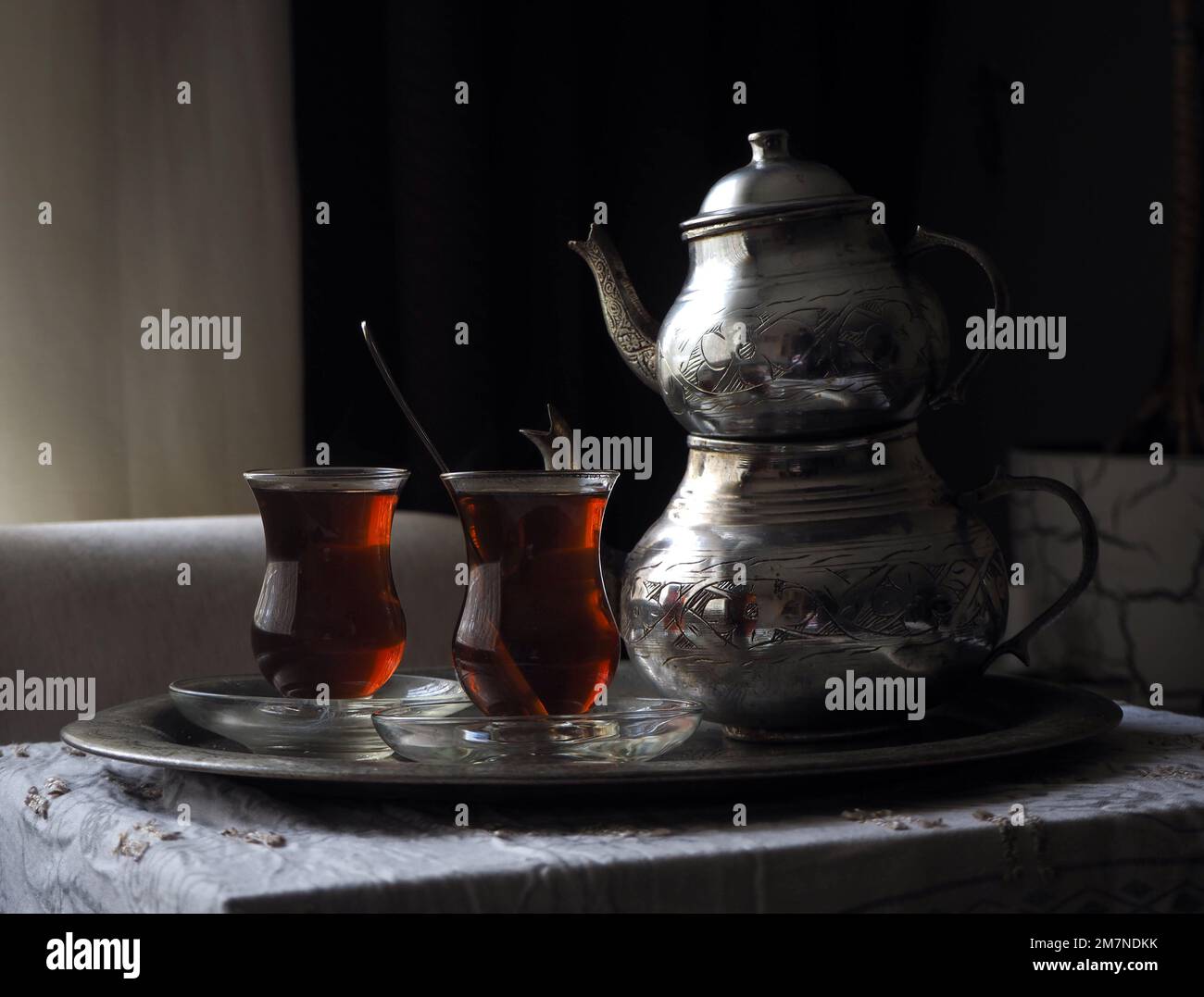 Traditioneller türkischer Teetisch im Loess Room. Klassische Teekanne aus Kupfer und zwei Gläser schwarzer Tee auf einem Tablett. Stockfoto
