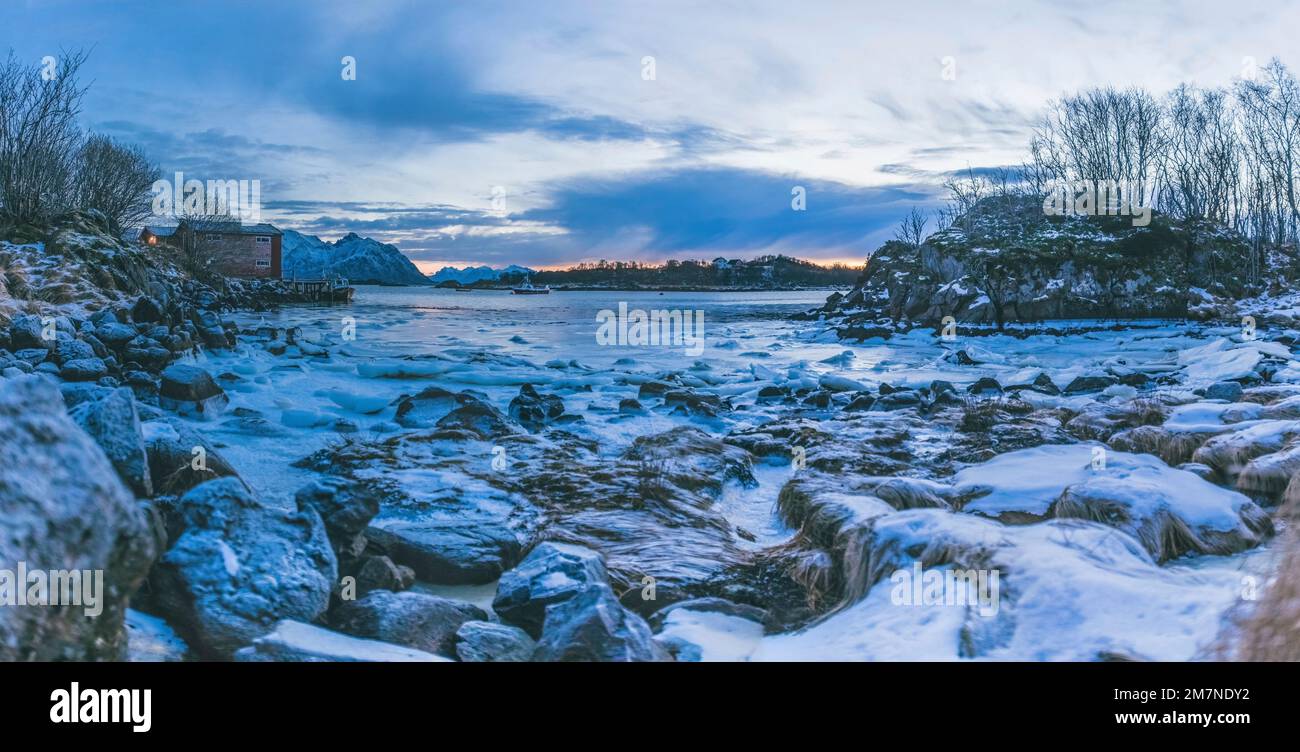 Kleiner alter Hafen im Fjord in Nordnorge, Norwegen, gefrorene und vereiste Oberfläche, Fjordlandschaft mit Meer und Boot, Panoramabild Stockfoto