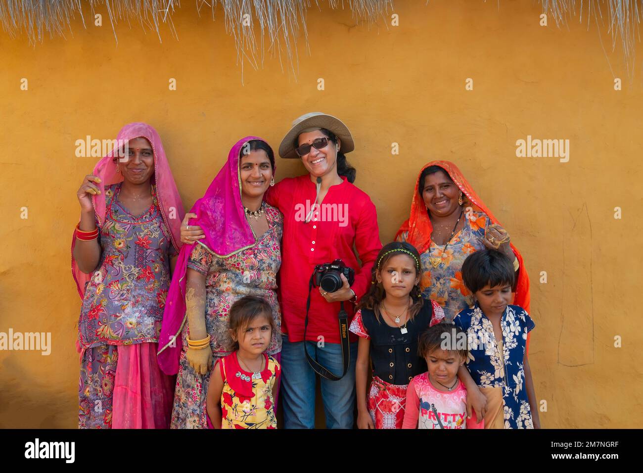 Jaisalmer, Rajasthan, Indien - 15. Oktober 2019 : weibliche Reisende und Fotografin posieren mit lächelnden und glücklichen Rajasthani Frauen und Kinder Stockfoto