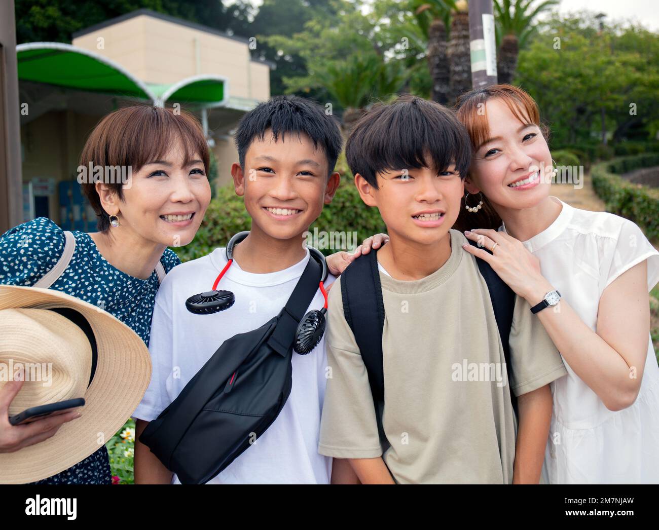 Vier Japaner auf einem Ausflug, zwei reife Frauen und zwei 13-jährige Jungen, hintereinander, lachend. Stockfoto