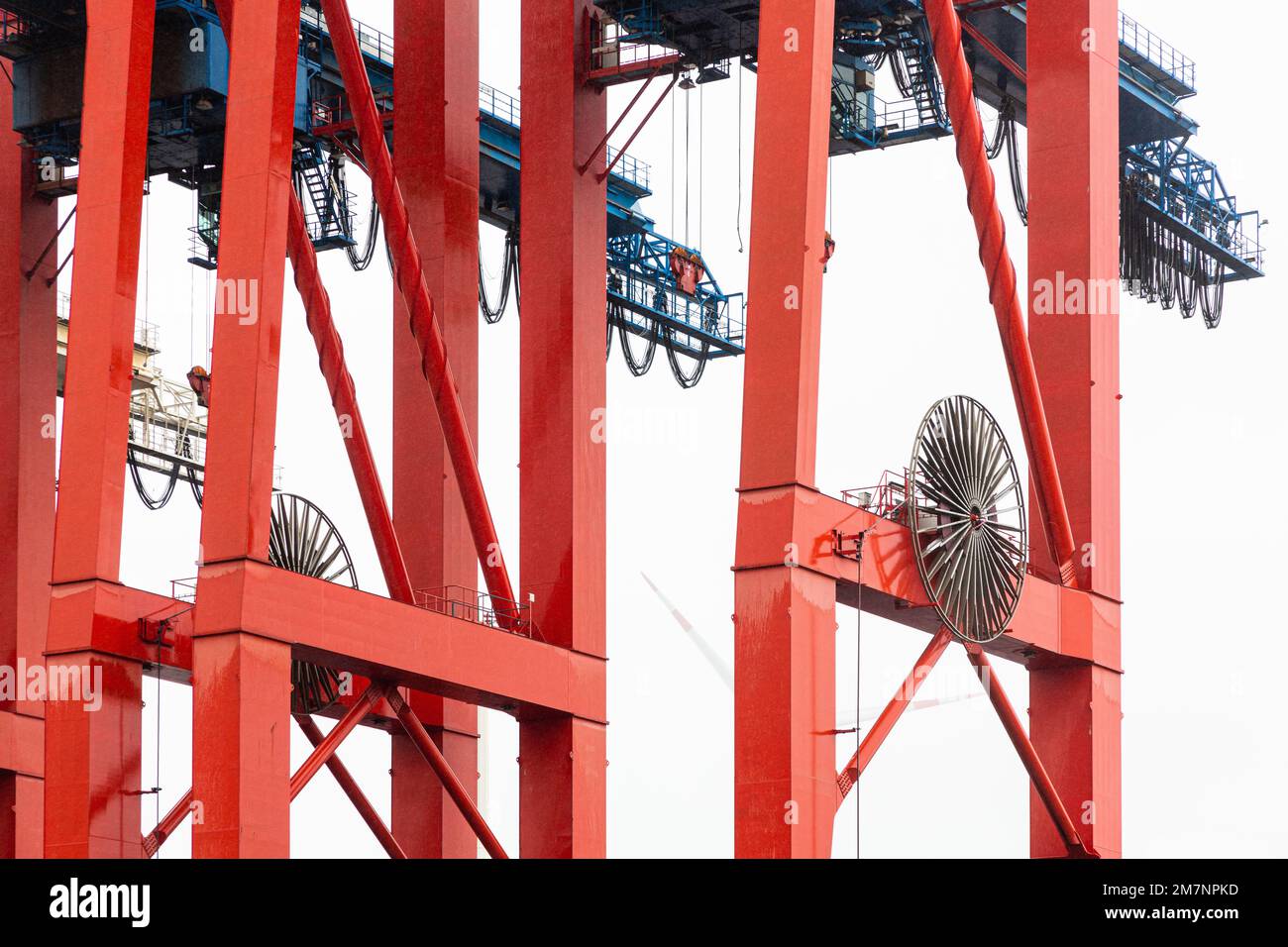 Ein roter Förderer im Hamburger Hafen wartet auf ein Containerschiff. Stockfoto