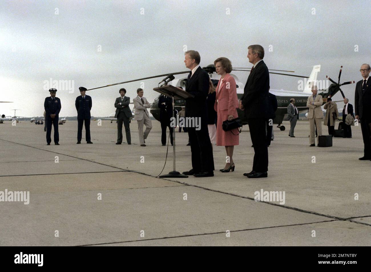 Rosalyn Carter und Vizepräsident Walter Mondale hören zu, wie Präsident Jimmy Carter nach seiner Rückkehr aus Europa vor einer Menge spricht. Basis: Luftwaffenstützpunkt Andrews Bundesstaat: Maryland (MD) Land: Vereinigte Staaten von Amerika (USA) Stockfoto
