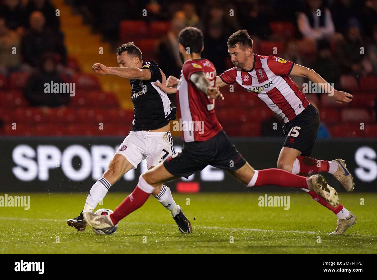 Der Shaun Whalley von Accrington Stanley hat einen Schuss vom Adam Jackson (Zentrum) und Paudie O'Connor in Lincoln City während des Papa Johns Trophy Quarter-Final-Spiels im LNER Stadium, Lincoln, blockiert. Foto: Dienstag, 10. Januar 2023. Stockfoto