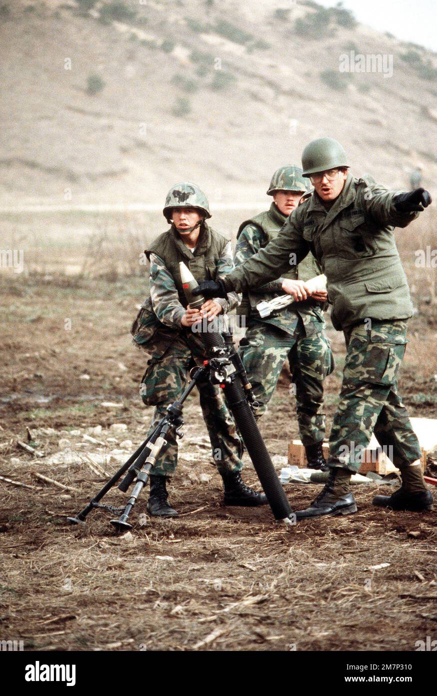 Sicherheitspolizisten wechseln sich ab und werfen Kugeln in einen M-29 81mm-Mörtel während des Schwerwaffentrainings am Rodriquez Range. Land: Südkorea Stockfoto