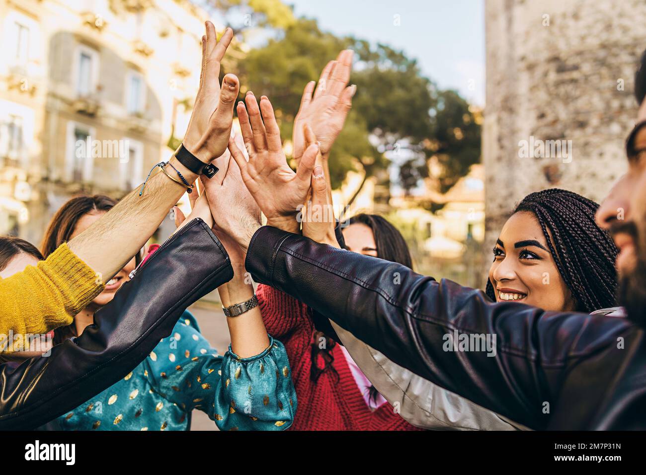 Eine vielfältige Gruppe junger Menschen ist glücklich, sich gegenseitig High-Five zu geben - Nahaufnahme von jungen Erwachsenen, die aus verschiedenen Rassen stammen und sich gegenseitig gratulieren Stockfoto