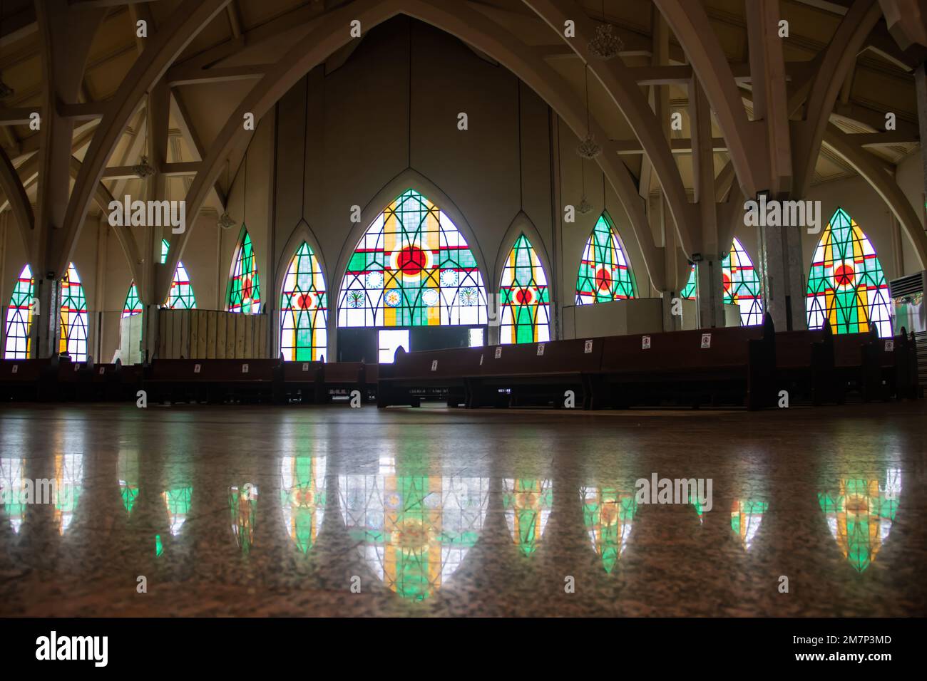 Innenraum mit bunten religiösen Motiven auf Buntglasfenstern in der katholischen Kirche in Abuja, die Kirche ist als nationales christliches Zentrum bekannt Stockfoto